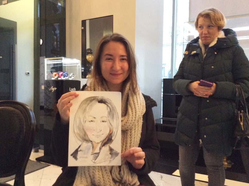 Наташа позирует шаржисту Мишелю на корпоративе в магазине 